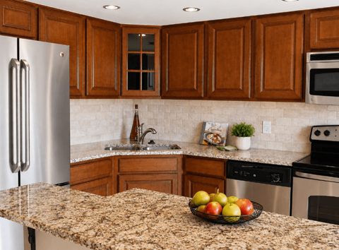 A kitchen with a granite countertop and a bowl of fruit on it.