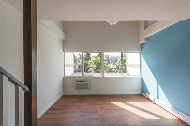 an empty room with a window and a wooden floor