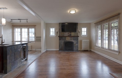 an empty living room with a fireplace and a tv