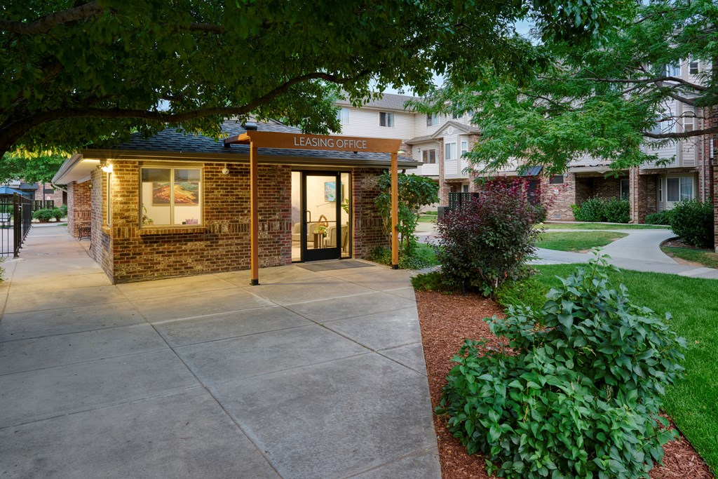 A brick building with a glass door and a sign that says "Leasing Office".