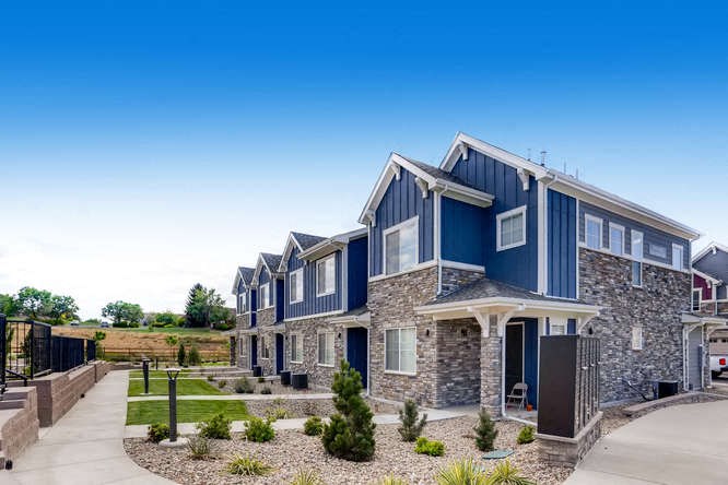 a row of houses with stone and blue roofs