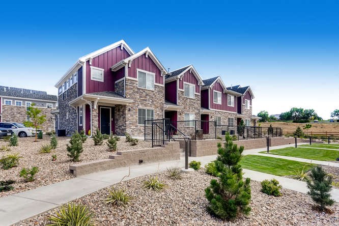a row of houses with gravel and landscaping