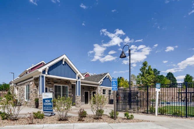 the front of a house with a black fence