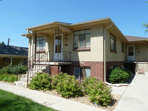 A house with a balcony and a bicycle in the driveway.