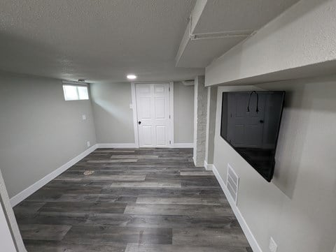 a living room with a tv on the wall and a hallway with a door