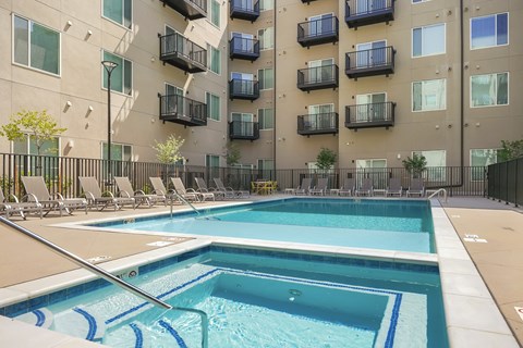 A large swimming pool in front of apartment buildings.