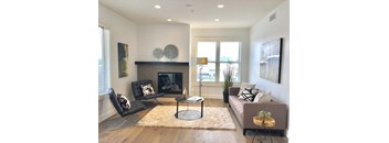 a living room with a couch and two chairs in front of a fireplace