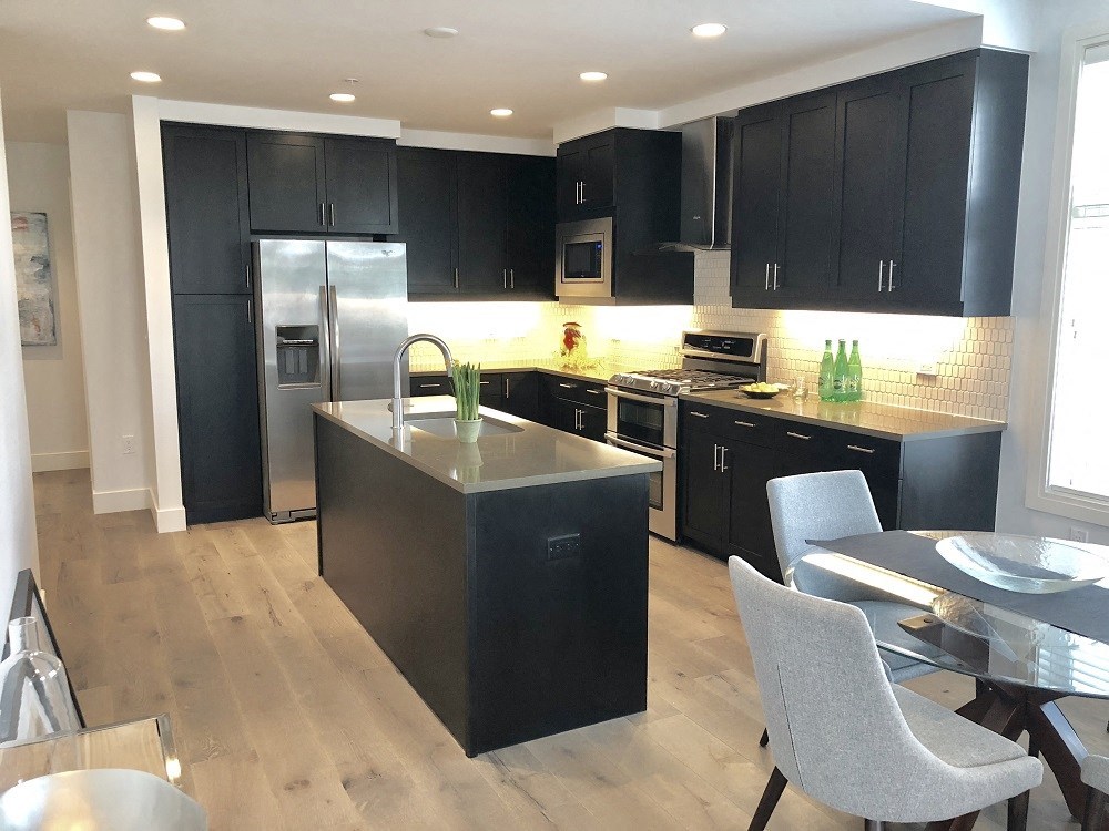 a kitchen with black cabinets and a stainless steel appliances