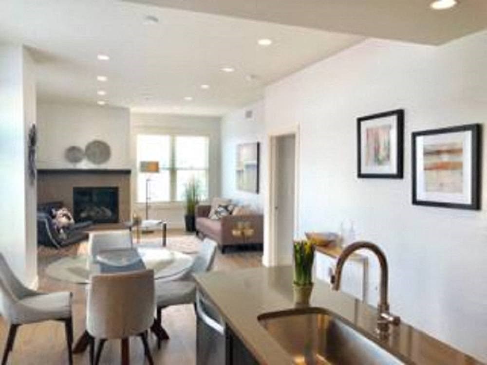 a kitchen and living room with a table and chairs