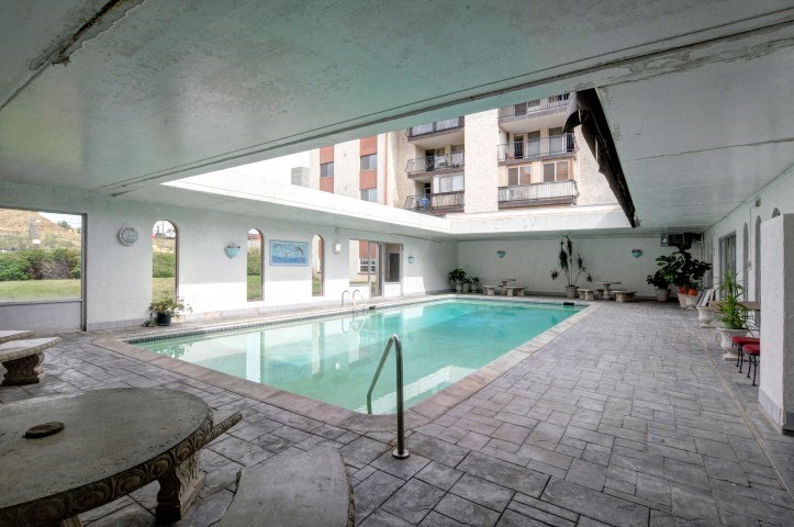 a swimming pool in an empty building with a large window
