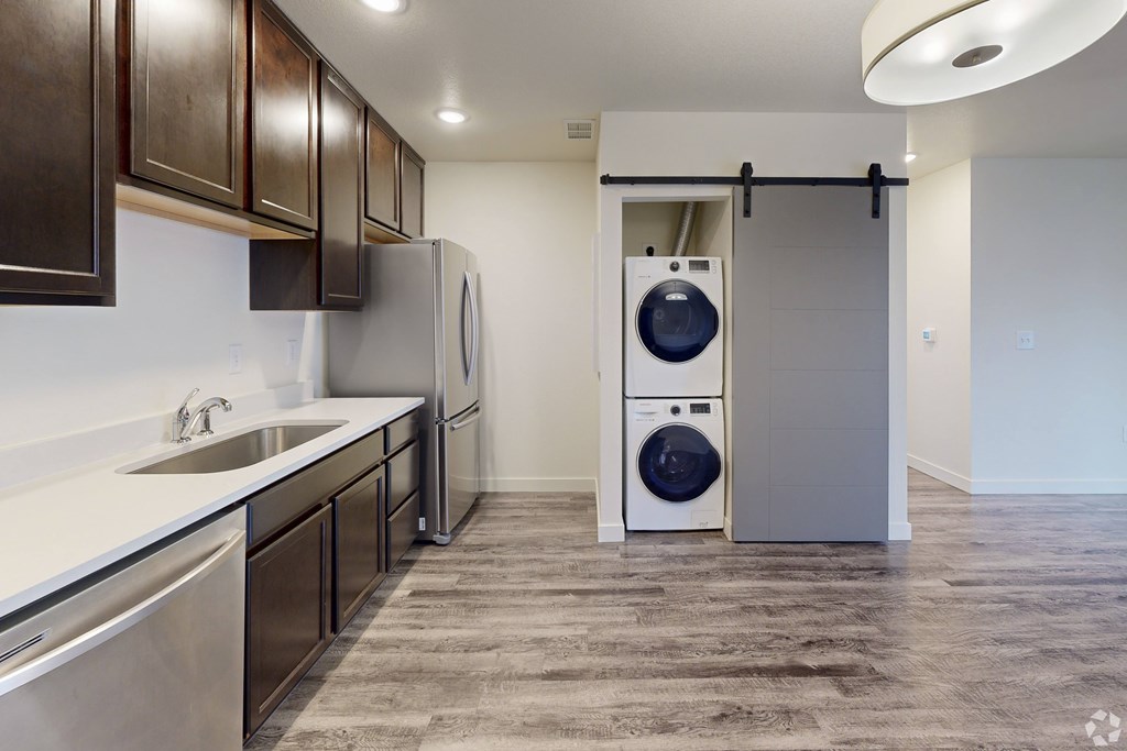 A modern kitchen with a washer and dryer in the laundry room.