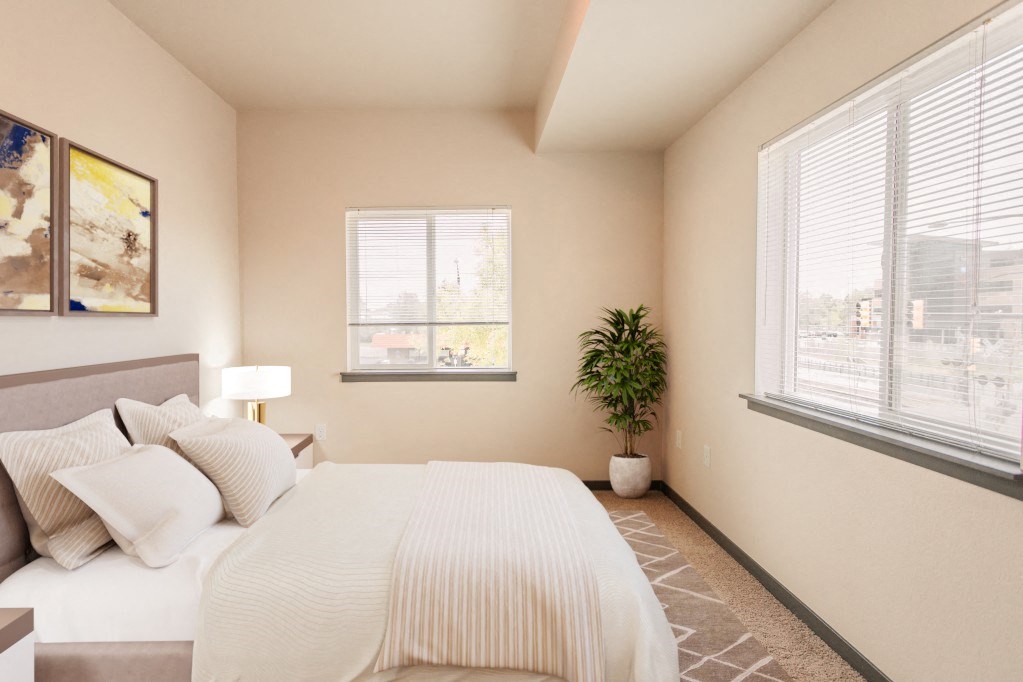 a bedroom with a large white bed and two windows