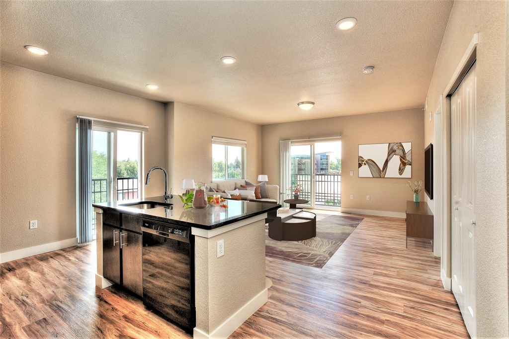 an open kitchen and living room with a couch and a table