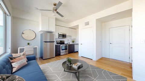 A modern kitchen with a blue couch and a coffee table.