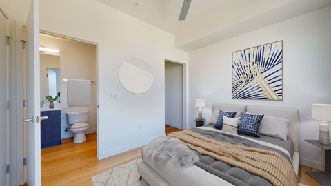 A bedroom with a bed, a nightstand, and a painting on the wall.