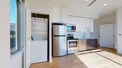 A modern kitchen with stainless steel appliances and white cabinetry.