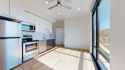 A modern kitchen with wooden floors and stainless steel appliances.