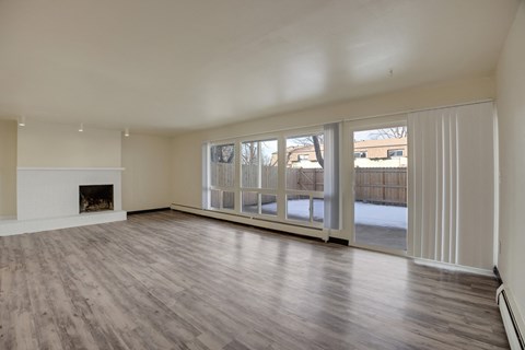 A spacious living room with a fireplace and sliding glass doors.