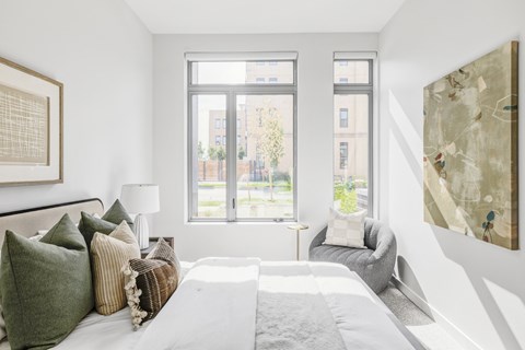 A bedroom with a large bed and a large window.