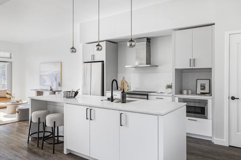 A modern kitchen with white cabinets and a large island.