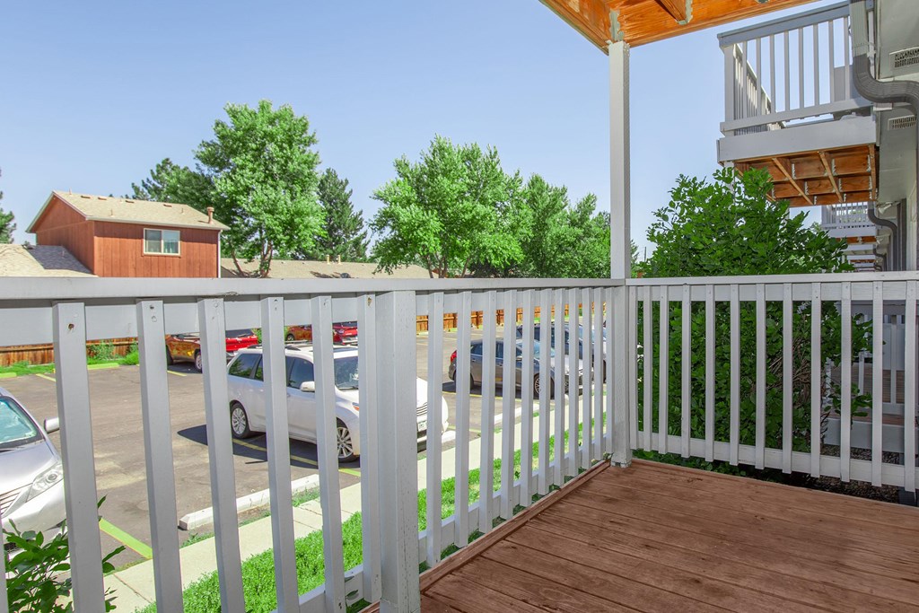 A white picket fence separates a house from a parking lot.
