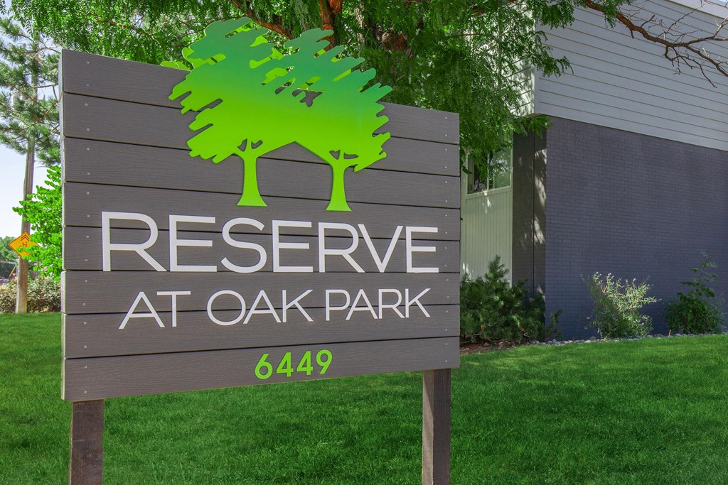 A sign for Reserve at Oak Park with a green tree graphic.