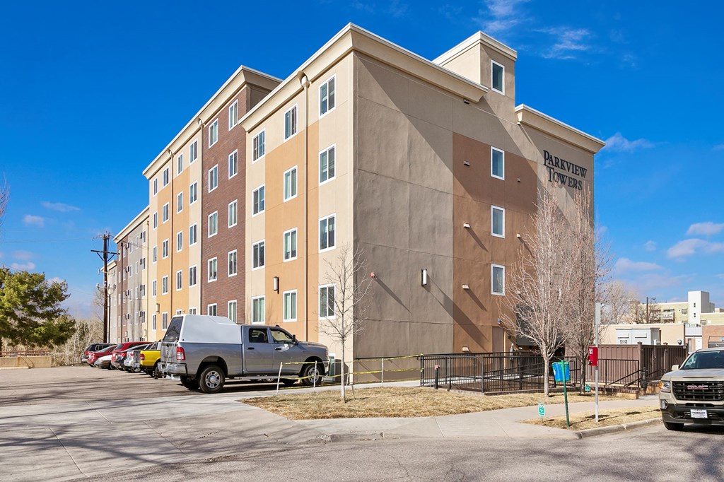 a large apartment building with cars parked in front of it