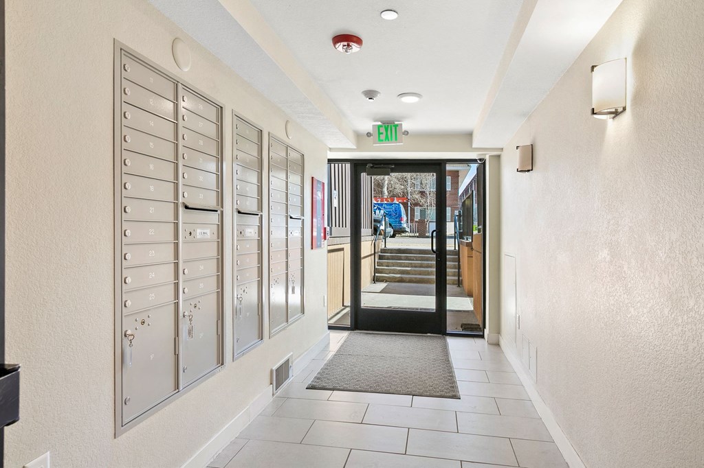 a long hallway with many lockers and a exit sign