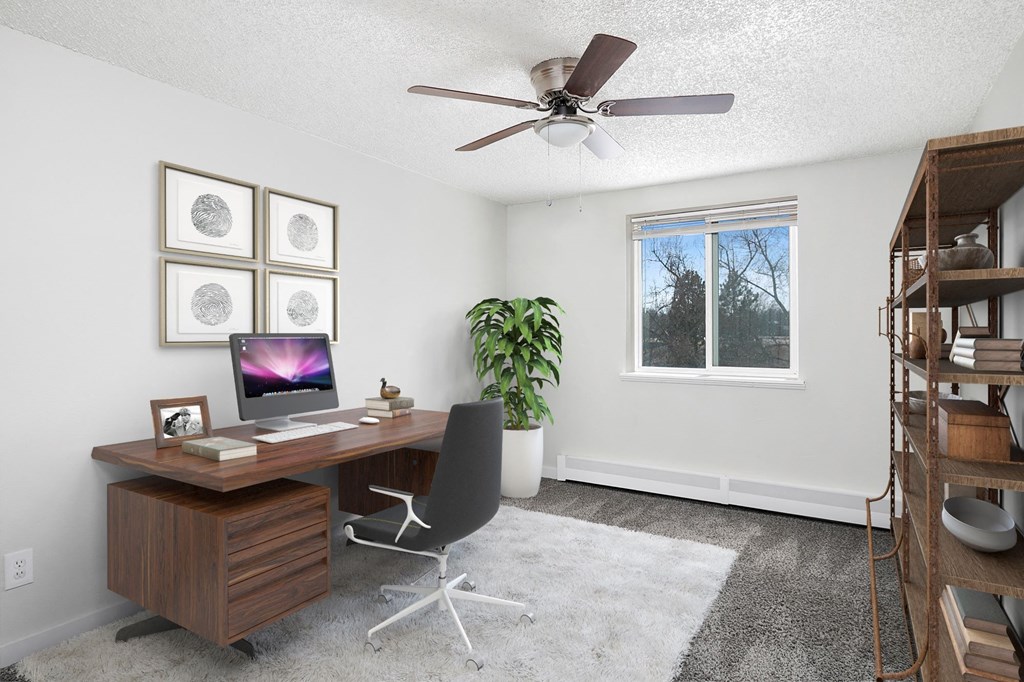 an office with a ceiling fan and a desk with a computer