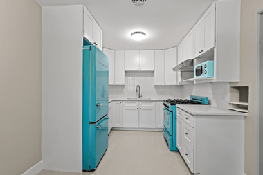 a kitchen with white cabinets and blue appliances