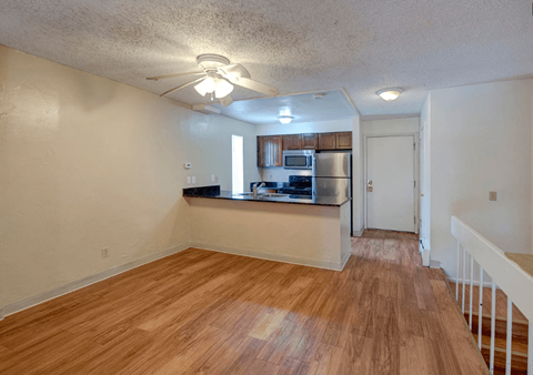 A room with wooden flooring and a white ceiling fan.