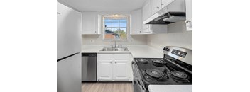 A kitchen with white cabinets and a black stove top.