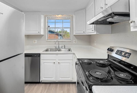 A kitchen with white cabinets and a black stove top.