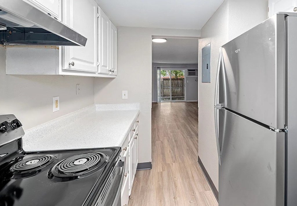 A kitchen with a black stove top and a white counter top.