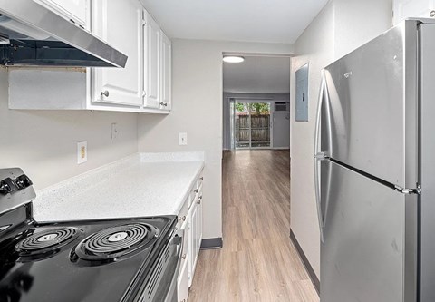 A kitchen with a black stove top and a white counter top.