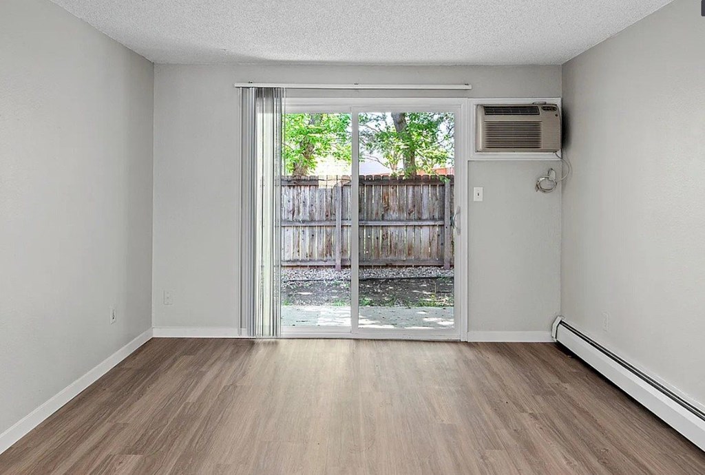 A room with a sliding glass door leading to a backyard.