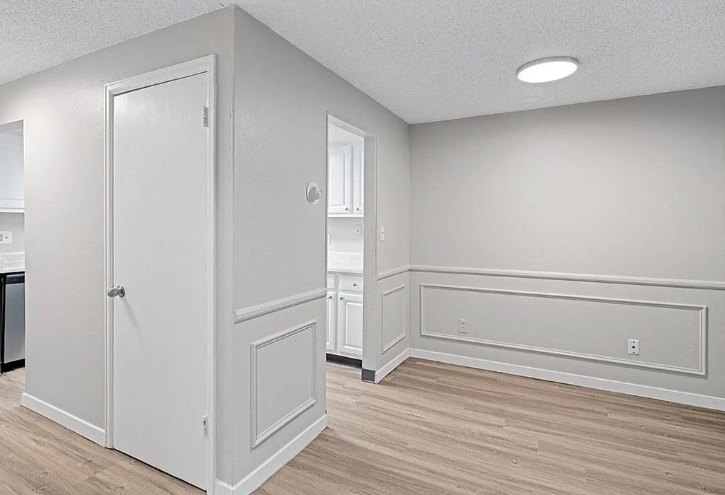 A white door is in a room with wood flooring.