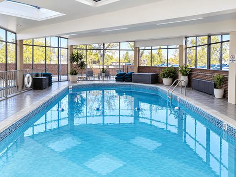 A large indoor swimming pool with a skylight above it.