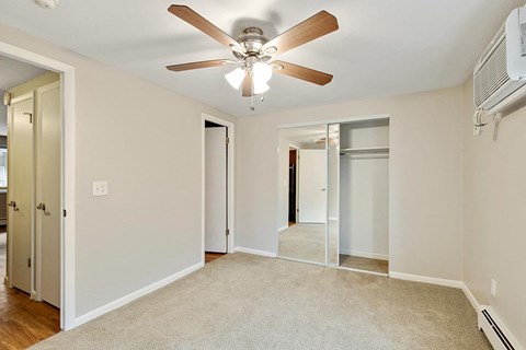 A room with a ceiling fan and a carpeted floor.