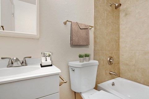 A white toilet with a towel hanging on the wall.