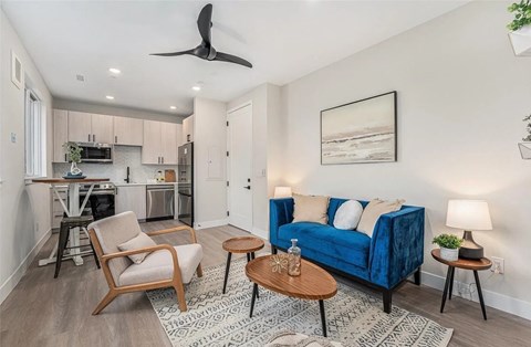 A living room with a blue couch, a wooden chair, and a coffee table.
