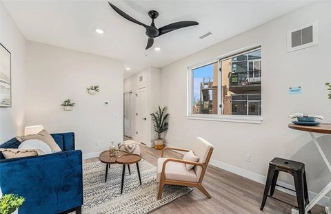 A living room with a blue couch, a wooden chair, and a coffee table.