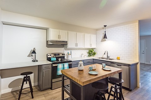 A kitchen with a table and chairs in the middle of it.