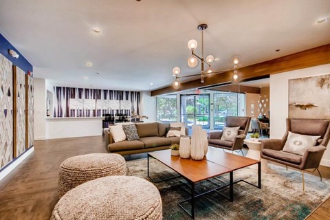 A living room with a brown sofa, a wooden coffee table, and a large painting on the wall.