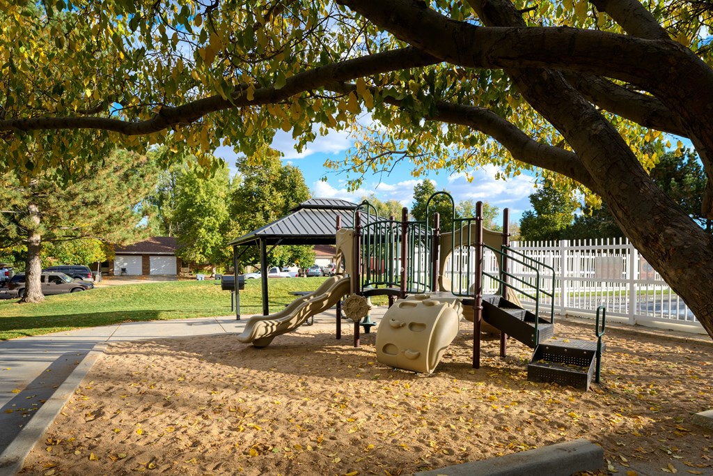 A playground with a slide, sandbox, and climbing structure.