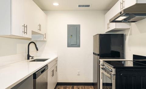 A kitchen with a black refrigerator and a black oven.