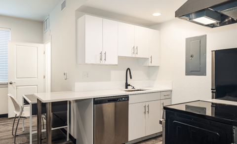 A modern kitchen with white cabinets and stainless steel appliances.