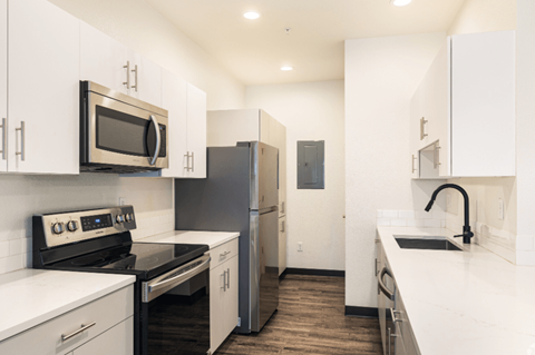 A kitchen with white cabinets and appliances.
