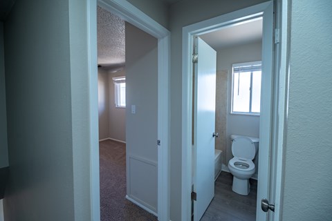 A bathroom with a toilet and a window.