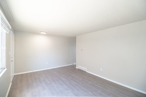A room with a light brown floor and white walls.